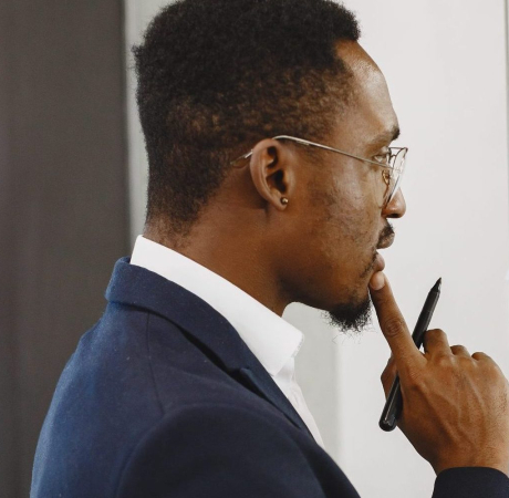 African man in a black suit. Man writing on the glass.